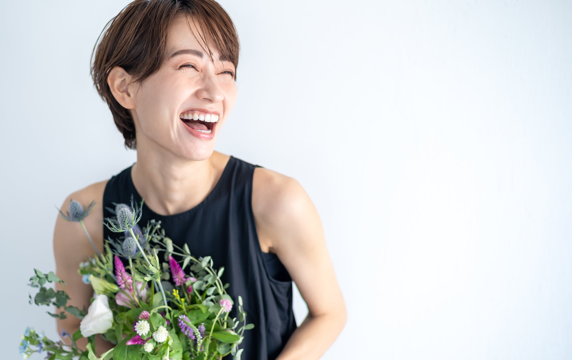 ホワイトニングをした白いはを見せて笑う女性
